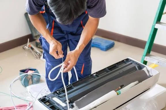 Technician servicing a disassembled indoor climate-control unit